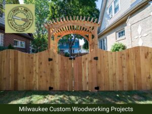 A custom wooden fence with an elegant arched gate and pergola entrance by Chisel + Vine in Milwaukee, WI.