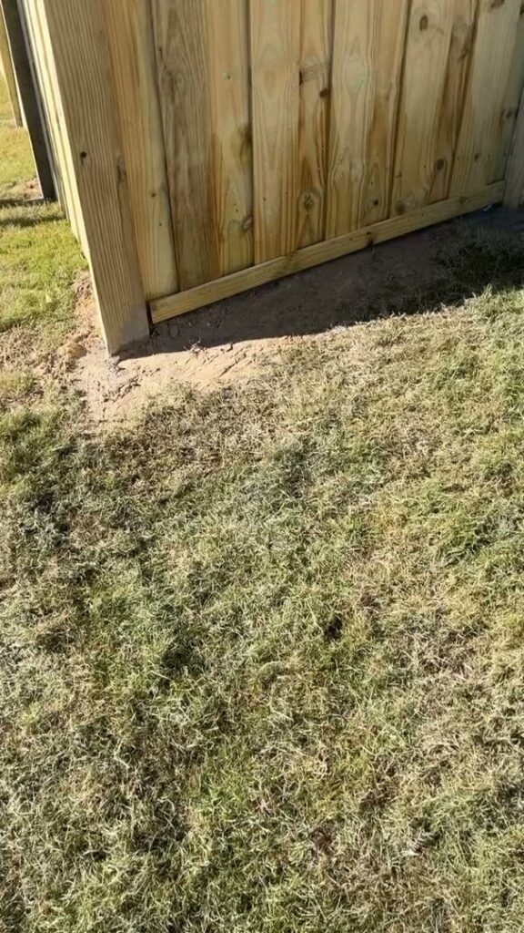 Close-up of the base of a wooden fence installation by JB Nealy Fence in Elgin, SC.