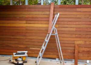 A wooden fence under construction with a ladder and tools, by Fence Company of Rhode Island in Providence, RI.