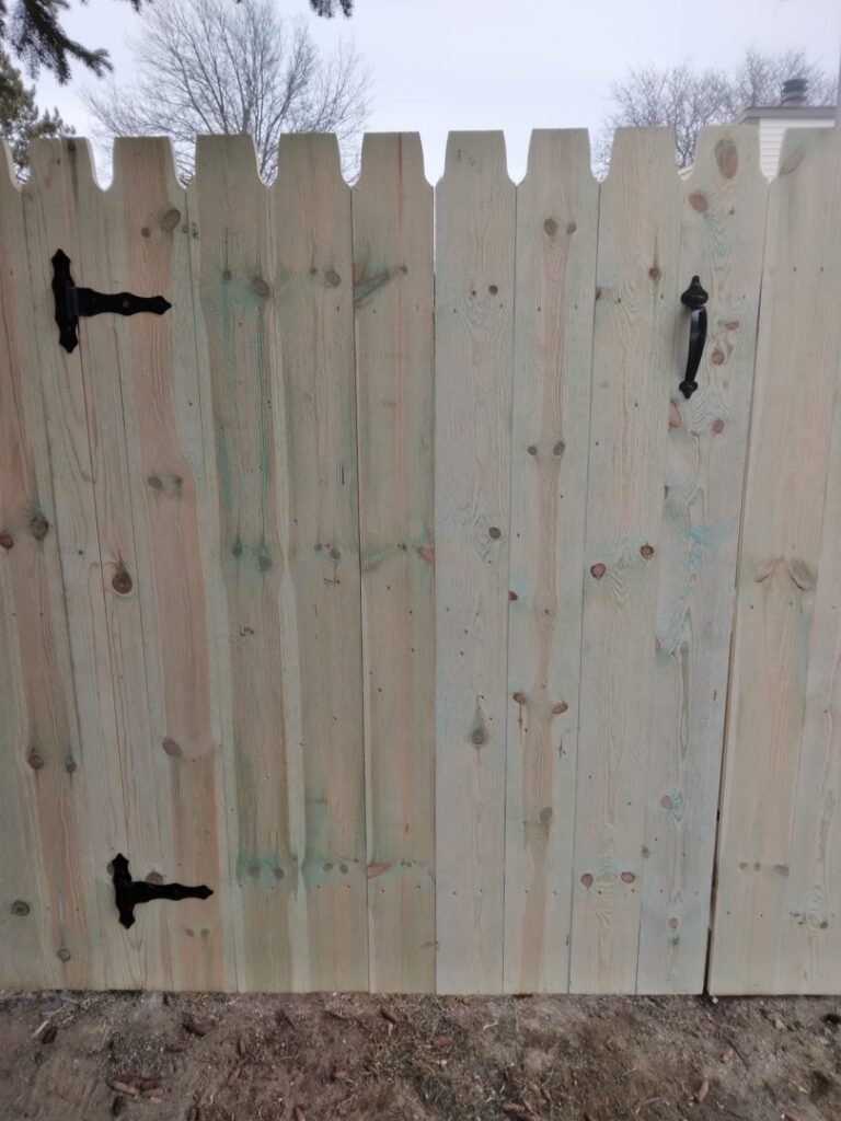 A close-up view of a newly installed wooden fence gate with black hardware, completed by Sparta Fencing in Ely, UK.