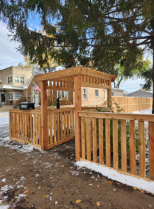A wooden fence with a decorative gate and pergola-style entry for a residential home by ALL STAR FENCE in Chicago, IL.