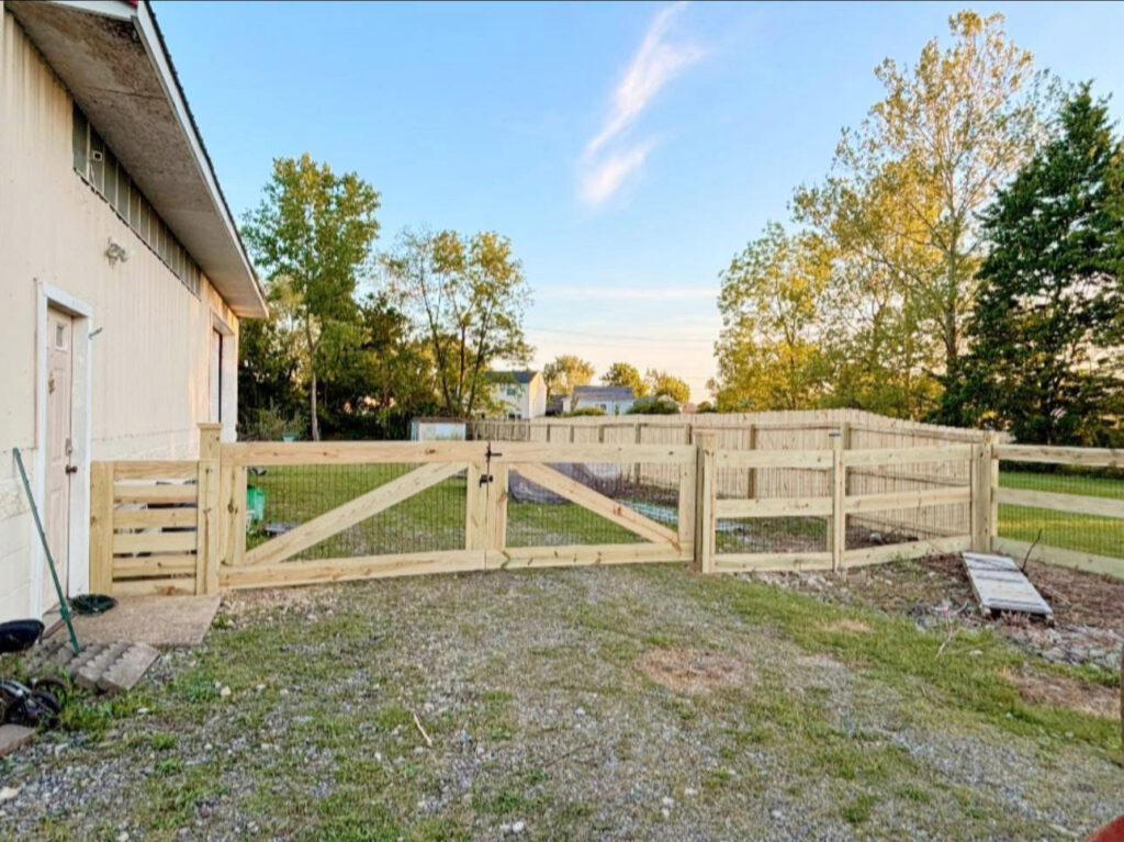 A newly installed wooden fence with a double gate on a residential property by D&M Renovation Services LLC in Columbus, OH.