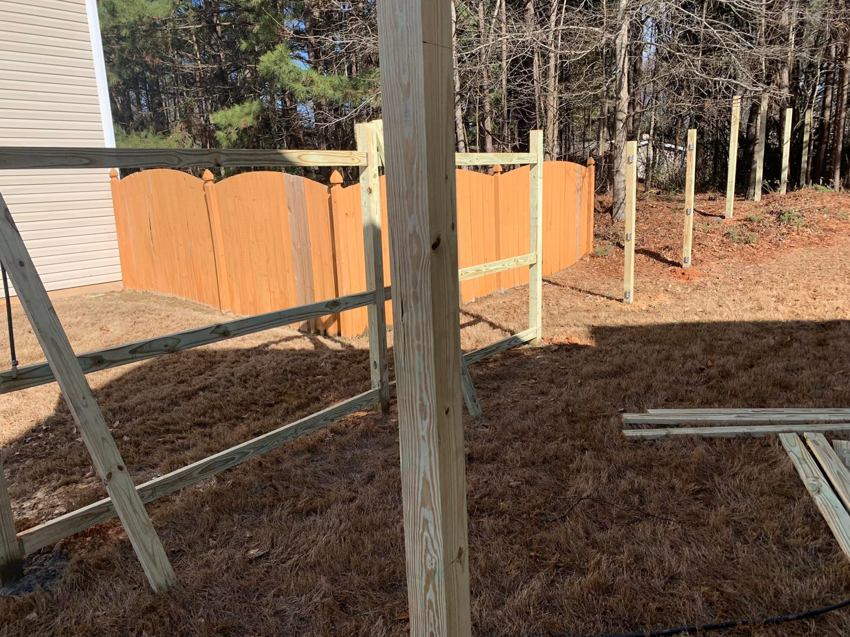 A new wooden fence installation in progress, showing posts and rails, by ETJ Fence and Restoration, INC. in Atlanta, GA.