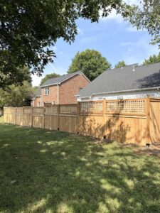 A wooden fence with a decorative lattice top for added privacy by Heron Building Co in Franklin, TN.