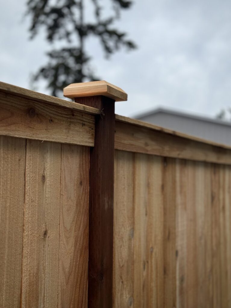 A close-up view of a wooden fence post with a decorative cap, installed by Fences NW LLC in Spanaway, WA