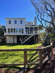 A wooden fence with a wire mesh gate enclosing a backyard area by Stono Fencing & Exteriors in Johns Island, SC