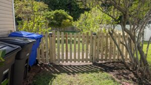 A wooden fence with wire mesh and a gate, perfect for pet containment, by Gifford Contracting & Repair in Goose Creek, SC.