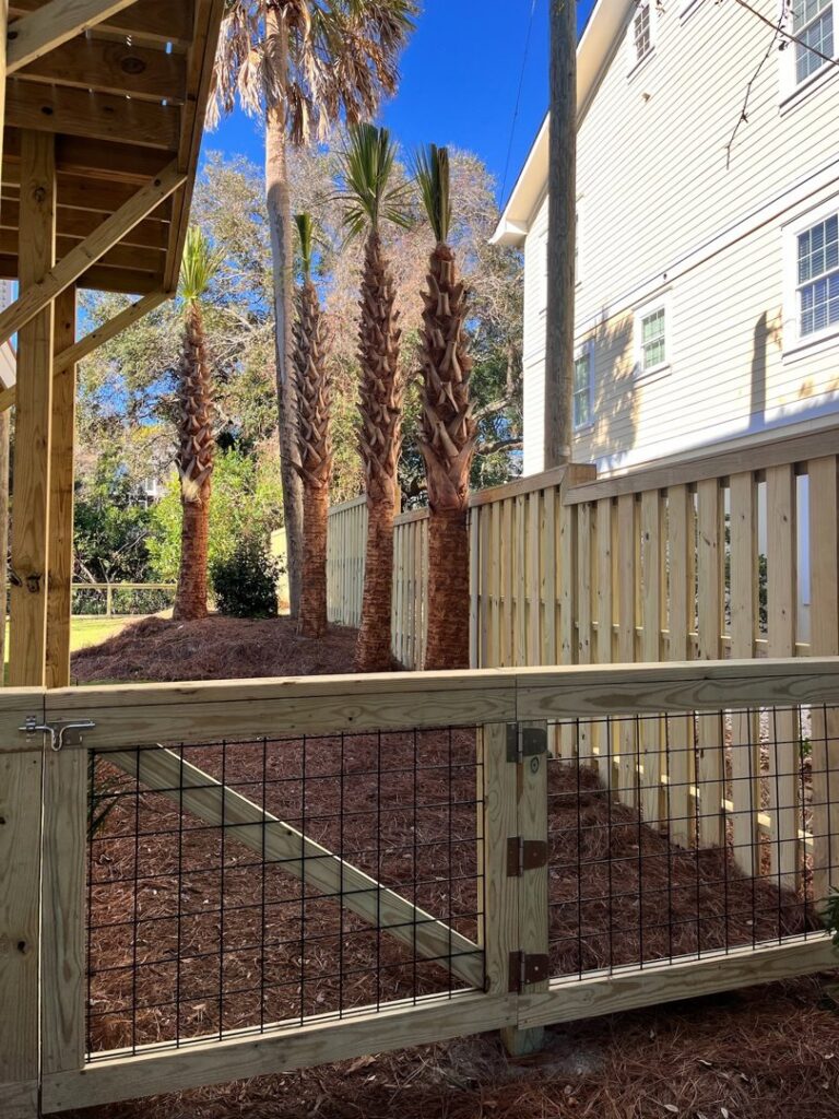 A wooden fence with a wire mesh gate providing access to a residential property by Stono Fencing & Exteriors in Johns Island, SC