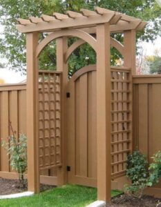 A decorative wooden fence featuring an arched gate and trellis panels installed by Valkyrie construction, LLC in Granville, OH.