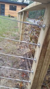 A modern wooden fence with horizontal cable railing installed by 802 Fence Company LLC in Shoreham, VT.