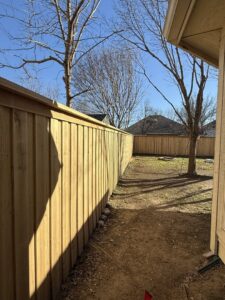 A newly installed wooden fence featuring solar lights by Backyard Builders in Rockford, MI.