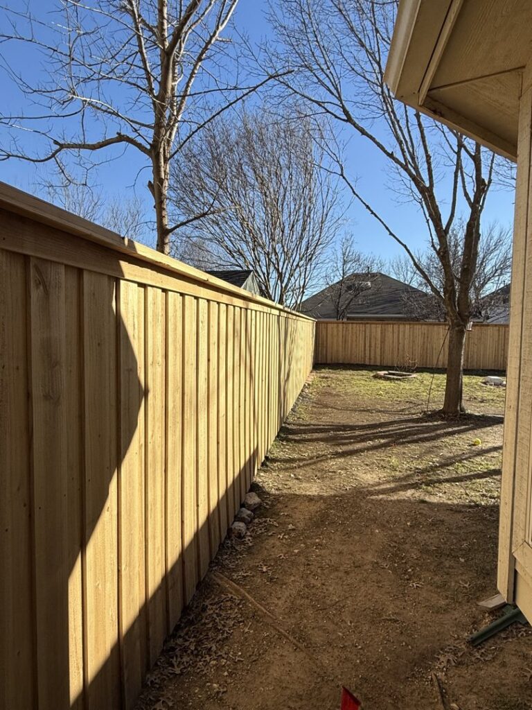 A newly installed wooden fence featuring solar lights by Backyard Builders in Rockford, MI.
