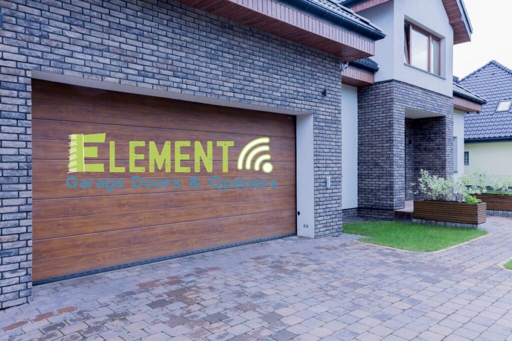 A stylish wooden garage door installed on a modern home by Element Garage Door Repair Of Portland, OR