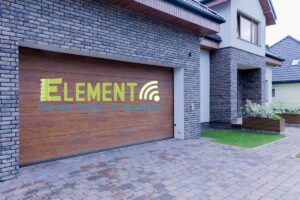A stylish wooden garage door installed on a modern home by Element Garage Door Repair Of Portland, OR