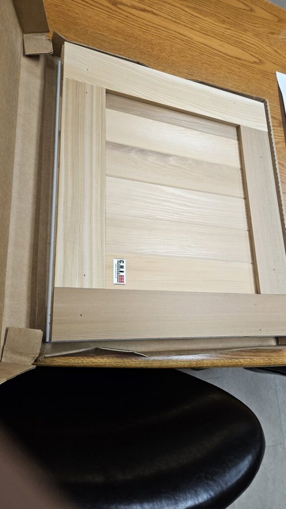 A wooden garage door panel sample, showcasing material options from Geiszler Garage Door in Milwaukee, WI.
