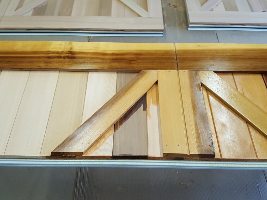 Close-up of wooden garage door panels showing different staining options offered by SCI Door in Yakima, WA