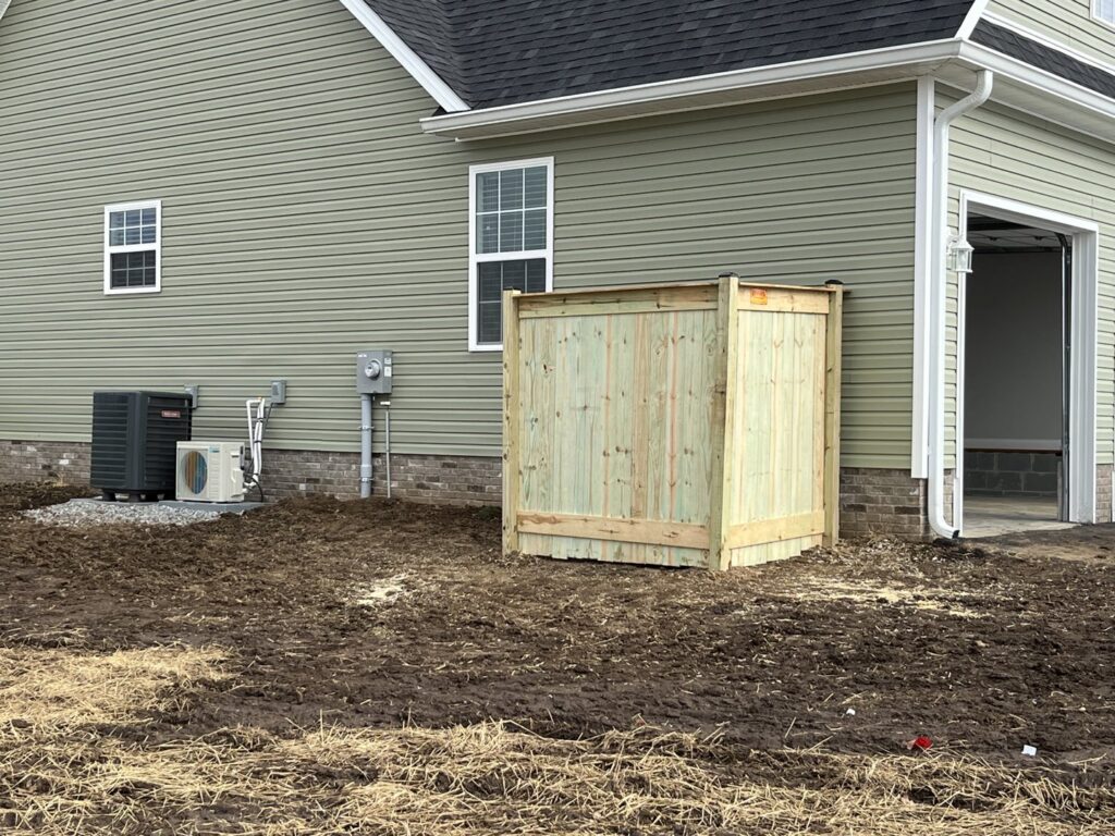 A custom-built wooden enclosure for an HVAC unit, providing aesthetic appeal and protection by Roark Fencing in Lexington, KY.