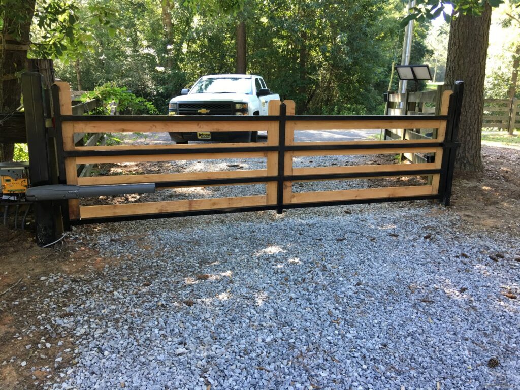 A wooden and metal combination automatic gate installed by Jefcoat Fence Co. Inc. of Hattiesburg, MS