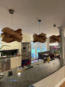 Decorative wooden pendant lights installed over a kitchen island by Armenergo Electrician in Rockville, MD