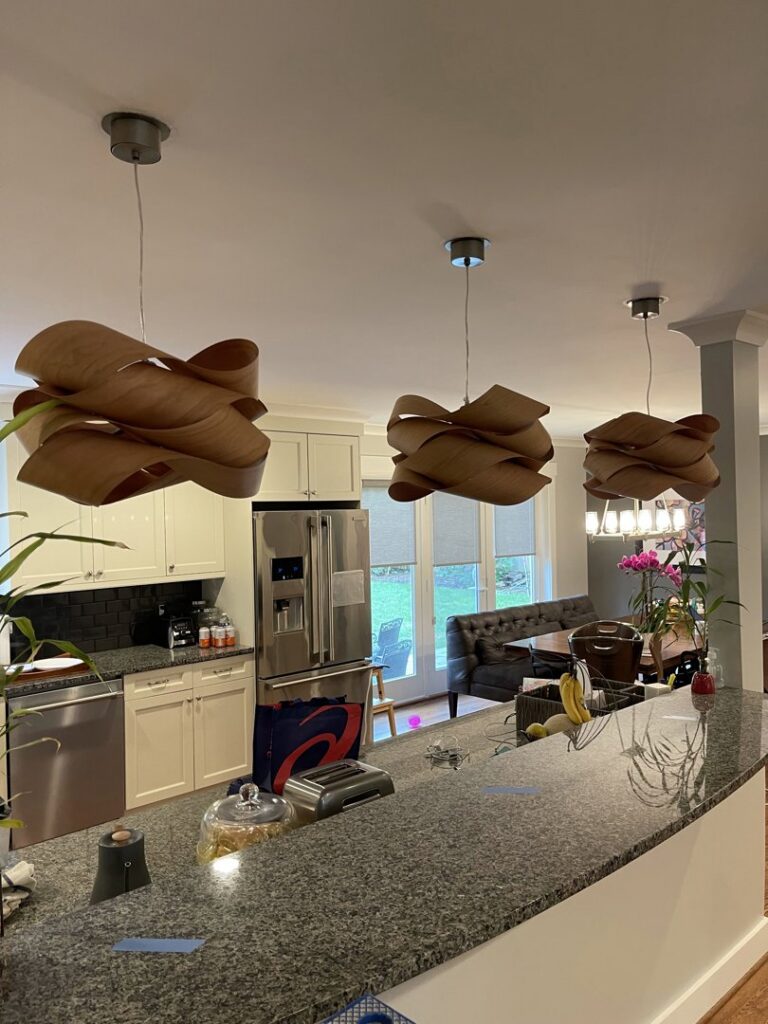 Decorative wooden pendant lights installed over a kitchen island by Armenergo Electrician in Rockville, MD