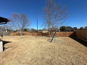 A newly installed wooden picket fence enclosing a residential backyard by Lynch's Temporary Fencing & Dumpster rental in Bossier City, LA.