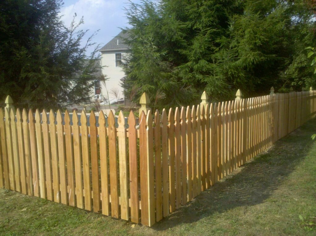 A wooden picket fence installed around a corner in a residential yard by Snyders Custom Fencing in York, PA.