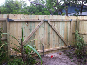 A sturdy wooden picket fence with a double gate installed by Hernandez Fence, a fencing contractor in Orlando, FL.