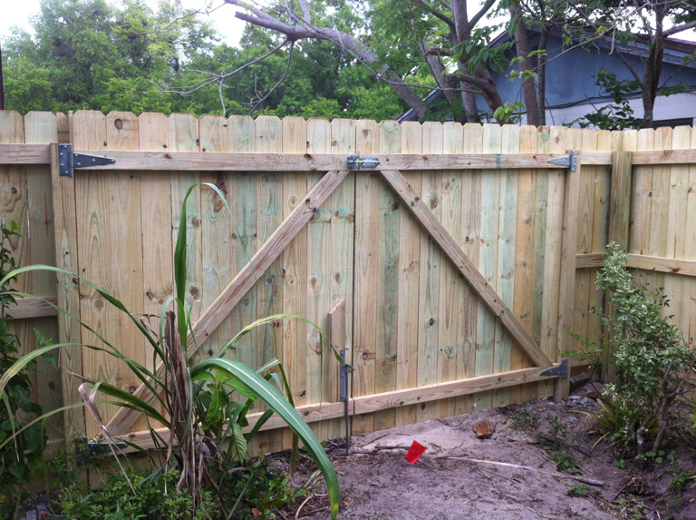A sturdy wooden picket fence with a double gate installed by Hernandez Fence, a fencing contractor in Orlando, FL.