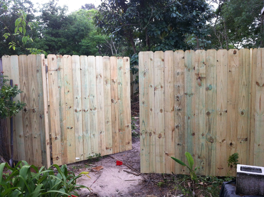 A wooden picket fence with a gate, showcasing quality installation by Hernandez Fence in Orlando, FL.