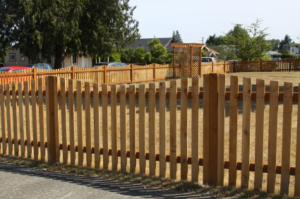 A newly installed wooden picket fence in a residential yard by Columbia Fence Co. in Columbia Station, OH.