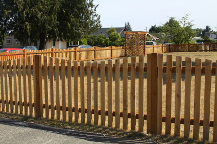 A newly installed wooden picket fence in a residential yard by Columbia Fence Co. in Columbia Station, OH.