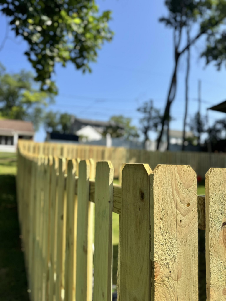 A newly installed wooden picket fence by Red Gate Fencing in Allentown, PA, providing a classic boundary.