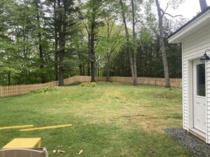 A newly installed wooden picket fence surrounding a residential yard by Doolan Fence in Montpelier, VT.