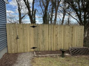 A classic wooden picket fence with a gate installed by White Eagle Fence Inc in New Haven, CT.