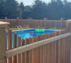A wooden safety fence installed around a swimming pool by Fence Company of Rhode Island in Providence, RI.
