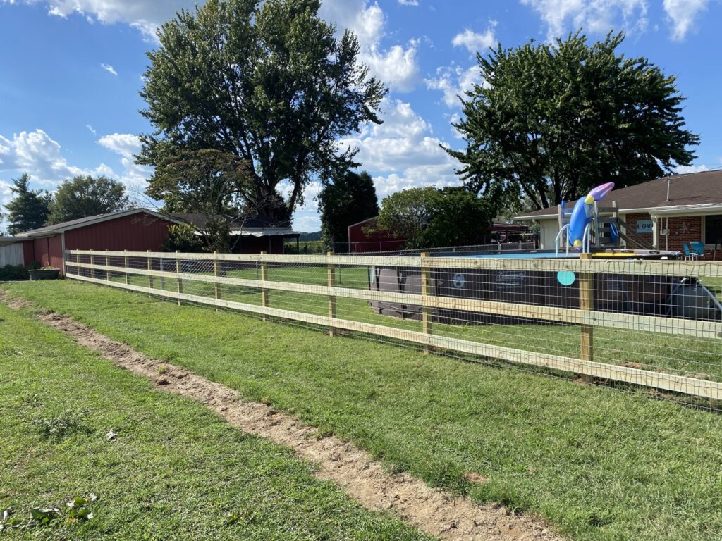 A wooden post and wire mesh fence installed next to an above-ground pool by Petty Fence Company LLC in Evansville, IN.
