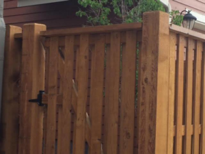 A close-up view of a sturdy wooden privacy fence with a matching gate, built by Colorado Fence and Gate Systems in Colorado Springs, CO.