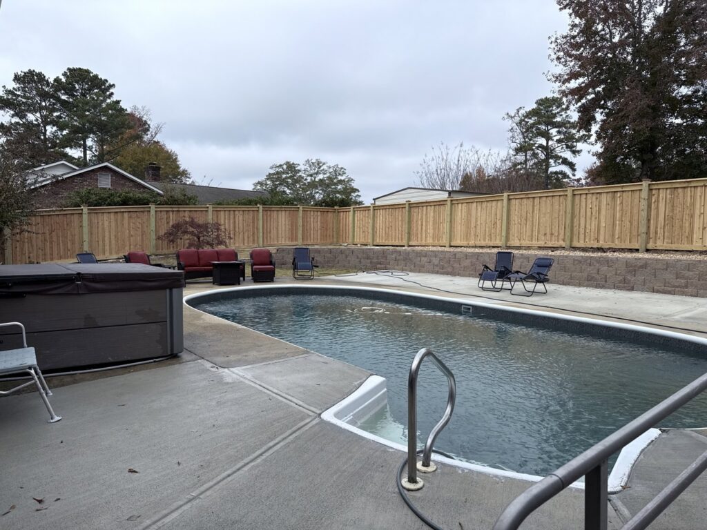A wooden privacy fence installed around a swimming pool by Creative Fence Designs in Columbus, GA.