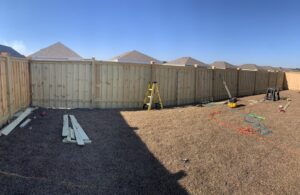 A wooden privacy fence installed in a backyard with construction tools nearby by Heavenly Gates Construction LLC in Miami, FL