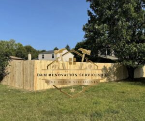 A newly installed wooden privacy fence with the D&M Renovation Services LLC logo, showcasing their work in Columbus, OH.