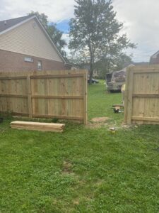 A wooden privacy fence under construction with lumber stacked nearby by Stapleton Fencing LLC in Lexington, KY.