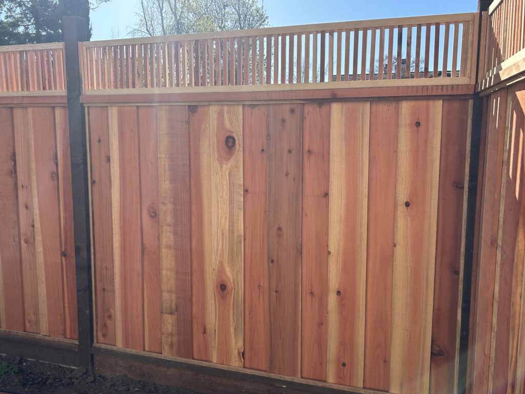 A newly installed wooden privacy fence with a decorative vertical slat top by Superior Fence & Rail in San Jose, CA.
