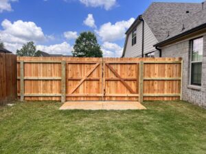 A new wooden privacy fence with a wide double gate installed by First Responder Outdoor Construction LLC in Bartlett, TN.