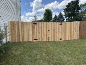A wooden privacy fence with a double gate, expertly installed by Hoplite Services in Indianapolis, IN.