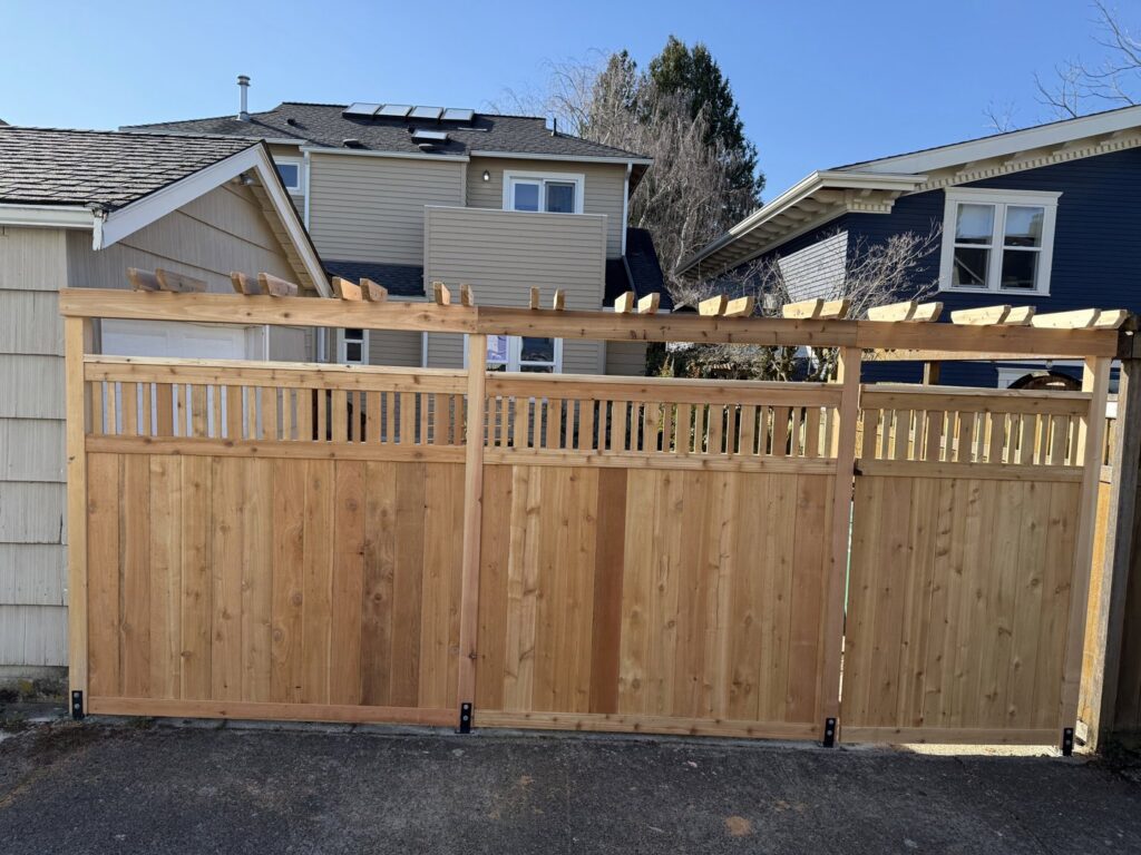 A wooden privacy fence with a double gate and decorative lattice top by Helmco Fences in Seattle, WA.