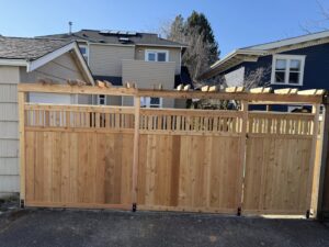 A wooden privacy fence with a double gate and decorative lattice top by Helmco Fences in Seattle, WA.