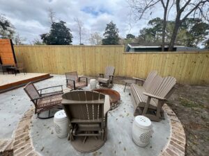 A wooden privacy fence enclosing a cozy outdoor fire pit area by Stono Fencing & Exteriors in Johns Island, SC
