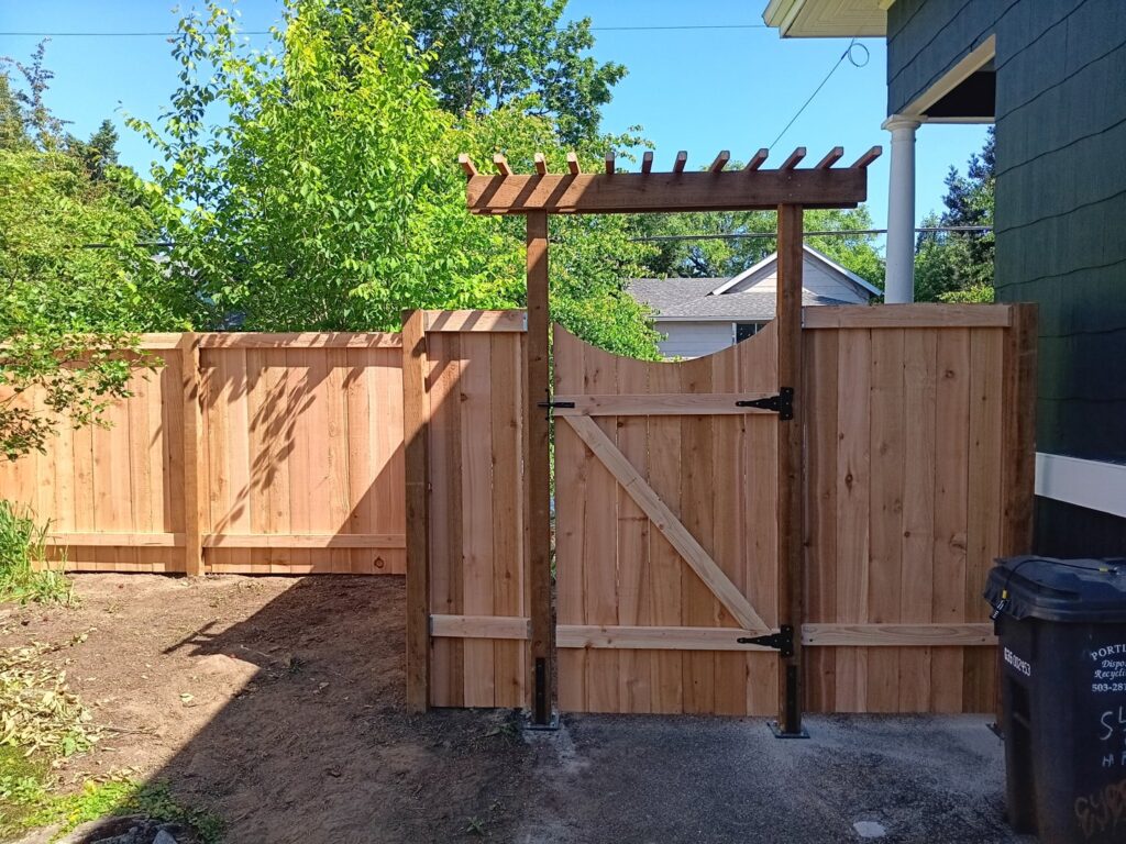 A wooden privacy fence with a matching gate and decorative arbor installed by Fix-A-Fence LLC in Portland, OR.