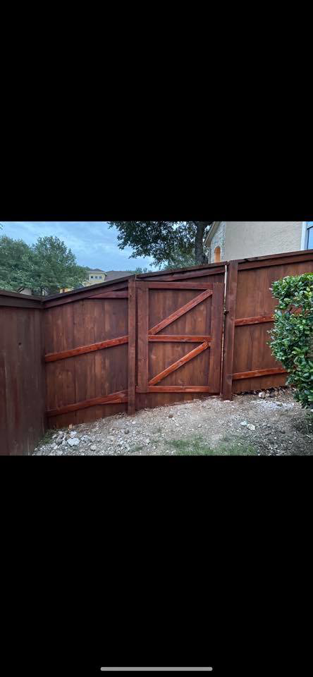 A sturdy wooden privacy fence with a custom gate installed by G Squared Fencing & Services LLC in New Braunfels, TX.