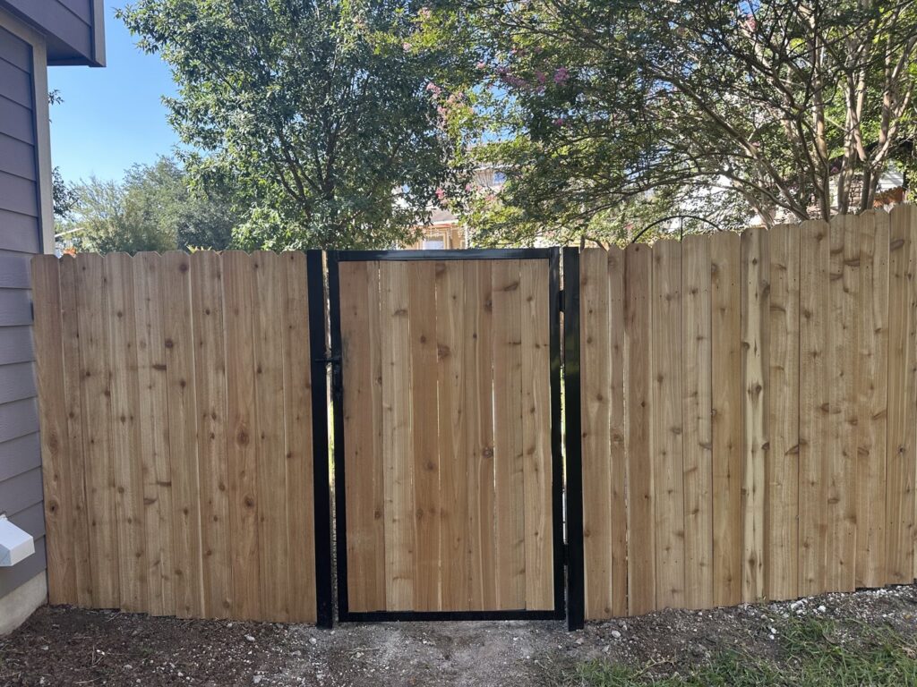 A newly installed wooden privacy fence with a gate by Landmark Fence & Deck Company in Saint Paul, MN.